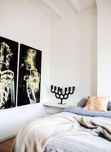 slaapkamer met bed en kunst in beeld